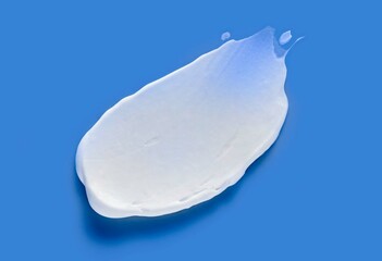 Cosmetic mask smudge sample texture. Mud, charcoal or  clay cleansing mask or face foam. Body slimming cream. On blue background