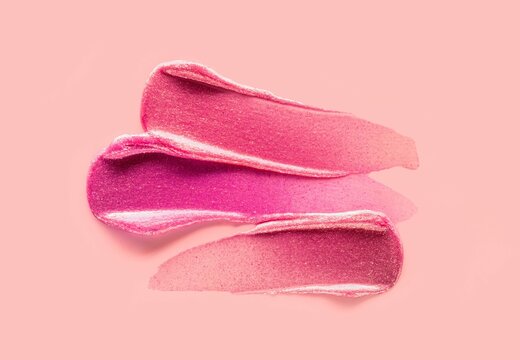 Lip gloss swatch or shimmering cosmetic gel mask sample on peach background