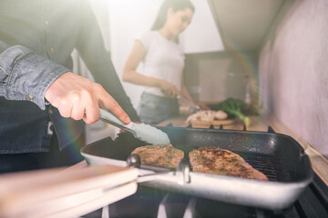 man fry beef steak together with girl cooking healthy food on we