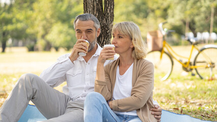 Portrait of happy elderly couple drink coffee together take care and love with good relationship...