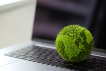 Technology with nature concept.Laptop keyboard with Green Globe on it. Carbon efficient technology....