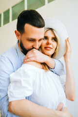 Portrait of future mother and father, husband hug pregnant wife. Happy family resting at home 