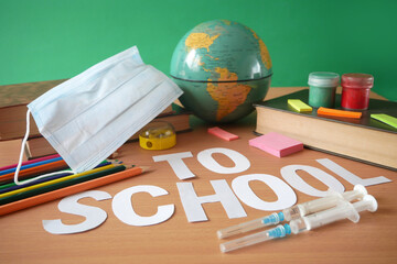 bottles and syringes of vaccine aganist covid-19 near book pile and school supplies, back to school...
