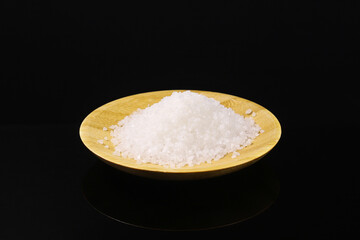 White rice in a wooden plate on a dark background. Close-up