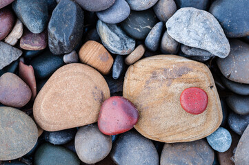 A close-up top view of the colorful beach stones and rocks on the beach. Abstract horizontal photo. Nature photography wallpaper. 
Blyth beach, Northumberland, UK. 