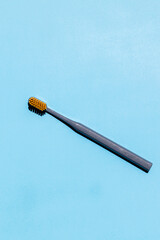 one toothbrush with orange bristles on a blue background