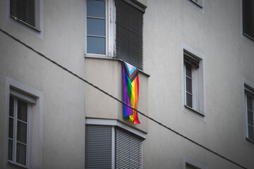 Rainbowflag hanging down from a balcony in the city, LGBT community, pride -diversity