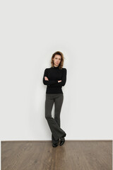 Serie of studio photos of young female model wearing stretch viscose turtleneck and basic flared trousers.	