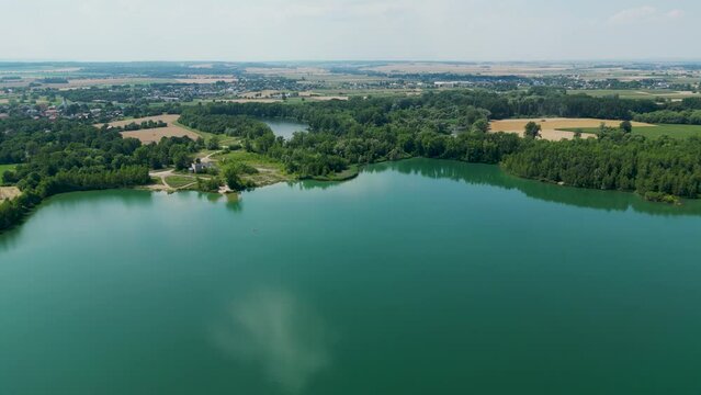 Arial air view on afloat gravel pit named Male Kalisovo jezero lake neat Bohumin city during spring afternoon with blue sky and few clouds