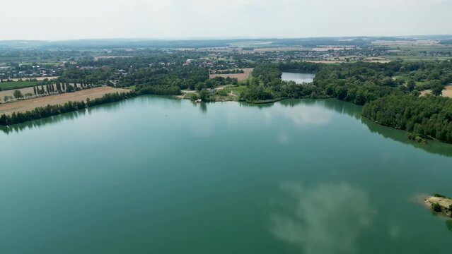 Arial air view on afloat gravel pit named Male Kalisovo jezero lake neat Bohumin city during spring afternoon with blue sky and few clouds