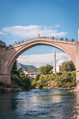 Fototapeta na wymiar MOSTAR, BOSNIA AND HERZEGOVINA - September 21, 2021: Man is preparing to jump from Stari most, Old Bridge, in Mostar. Bosnia and Herzegovina