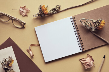 Mockup with blank album, notebook with spiral binder. Dry sunflower flowers and maple leaves
