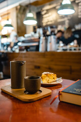 Sunday morning coffee and peach scone in a third-wave cafe reading book in a vertical shot