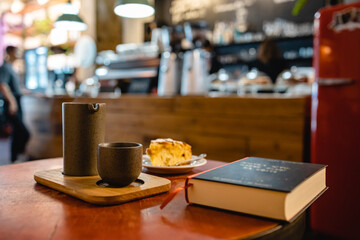 Sunday brunch with coffee and peach cake in a modern loft cafe atmosphere with book in horizontal...
