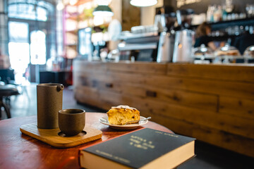 Morning breakfast with coffee and peach scone in a modern loft cafe atmosphere with a book in horizontal shot