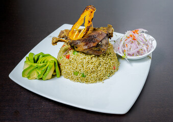 Rice with duck, accompanied by onion, lemon and lettuce. Peruvian food. White background.