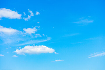 Several small white clouds on a blue sky background