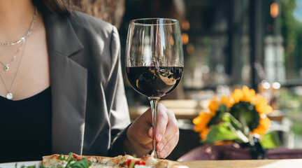 A glass of red wine in a restaurant on a table close-up.