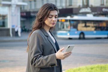 Business young woman with a smartphone on a blurred background of the city.