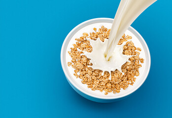 Oat granola with milk isolated on blue background, top view