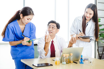 Team of doctors having a meeting  in medical office. Concentrated medical team using laptop and take notes.