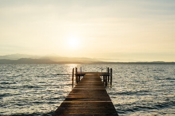 Obraz premium Pier on Garda lake at sunset, meditation background