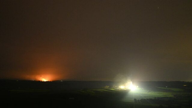 smoke rising over a hill in tasmania australia, from a burn off fire, with the hill above a farm land area.