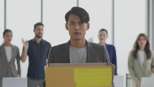 Employment crisis, Unhappy asian business man leaving work with box of things after dismissal.