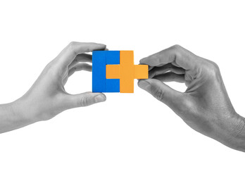 Man and woman hands with two matching puzzle pieces isolated on white background. Partnership,...
