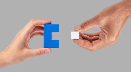 Man and woman hands joining two puzzle pieces. Partnership, connection concept. Partners suitable...