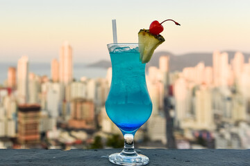 Drink azul com cidade ao fundo