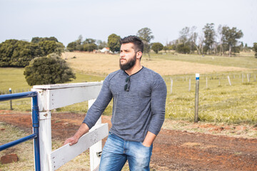 Portrait of a strong man with a beard with trees in the background