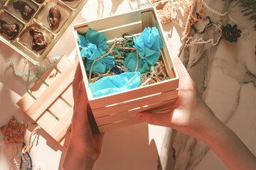 Teenage girl making handmade Christmas gift with chocolate sweets for New Year, Christmas holidays. Do it yourself concept, creativity, step by step process.