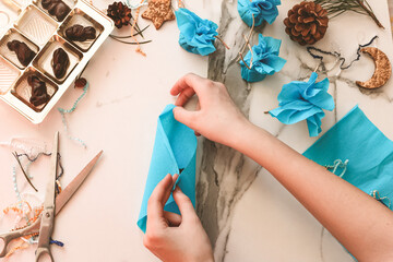 Fototapeta premium Teenage girl making handmade Christmas gift with chocolate sweets for New Year, Christmas holidays. Do it yourself concept, creativity, step by step process.