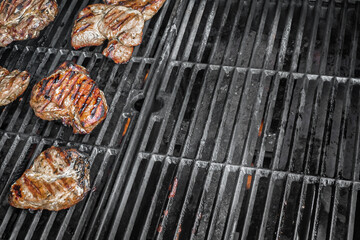 Smoked grill grate. Fried steaks. Barbecue background. Meat dishes. Cook on fire. Summer picnic. Smoked grill grate with fried steaks. 