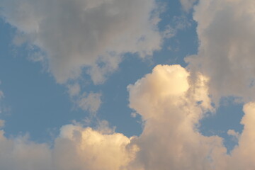 Fototapeta na wymiar cheerful bright fluffy clouds overhead at dusk