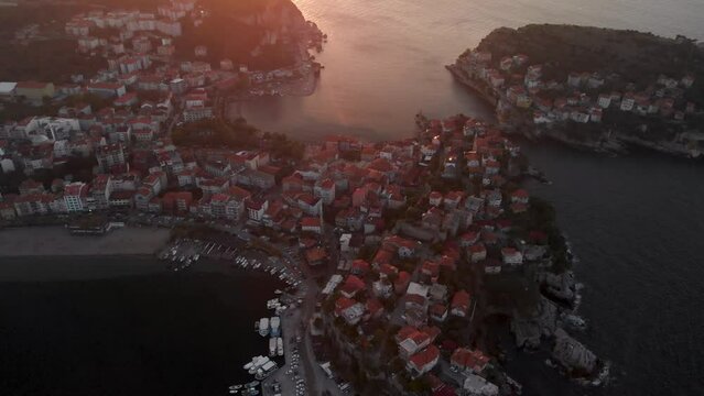 Flying over red rooftops of Amasra city, Turkey at sunset. Black Sea coastline in Bartin province