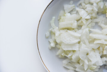 White onion cut into strips on a saucer
