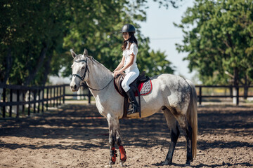 Teenage Girl in helmet Learning Horseback Riding.