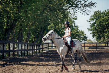 Teenage Girl in helmet Learning Horseback Riding.