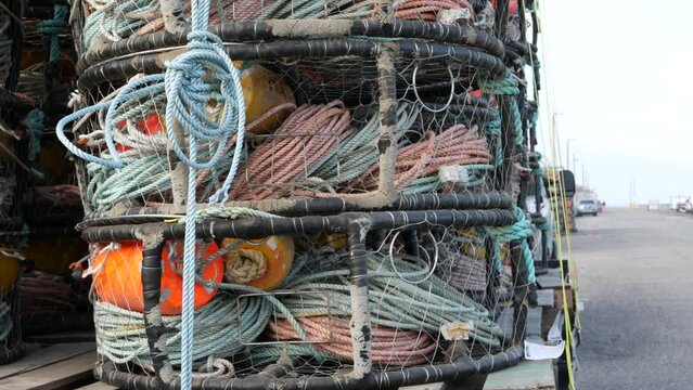 Traps, ropes and cages on pier, commercial dock, fishing industry, Monterey California USA. Empty pots, creels for fish seafood catching in port. Many fisherman's nets and baskets in seaport. Fishery.