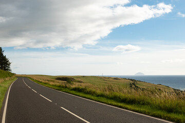 A pleasant road on the west coast of Scotland in Ayrshire on a sunny day with scenic view accross...