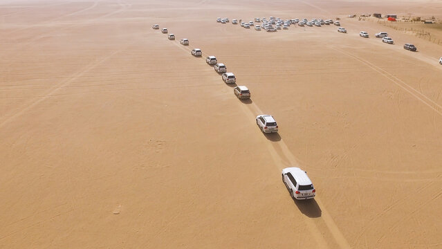 4x4 SUVs Cars Driving Through The Sand Dunes In The Desert Of Abu Dhabi. Stock. Top View On SUVs In The Desert