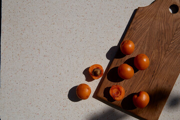 Fresh healthy summer fruits - apricots under hard shadows. Summertime. Copy space. Extra wide banner.
