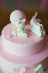 Pink cake with mirror glaze and white chocolate unicorn . Cake on a white cake stand. First birthday party concept
