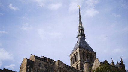 Old gothic castle on blue sky background. Action. Stone Gothic castle with pointed peak is...