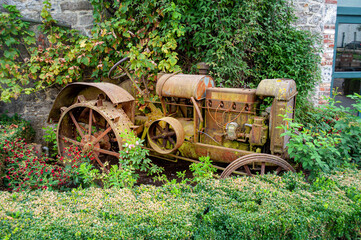 Fototapeta na wymiar vieux tracteur agricole, moteur à essence et roues métalliques