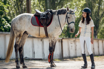 Young teenage girl equestrian having fun with her favorite horse. Dressage outfit