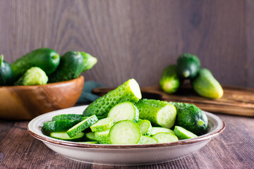 Ripe sliced cucumbers on a plate on the table. Organic diet food.