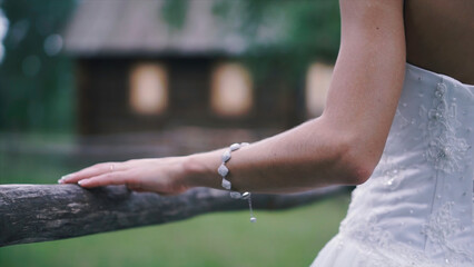 Close-up of bride's hands with on beautiful white wedding dress. Clip. Newlywed girl in outdoor near wooden fence